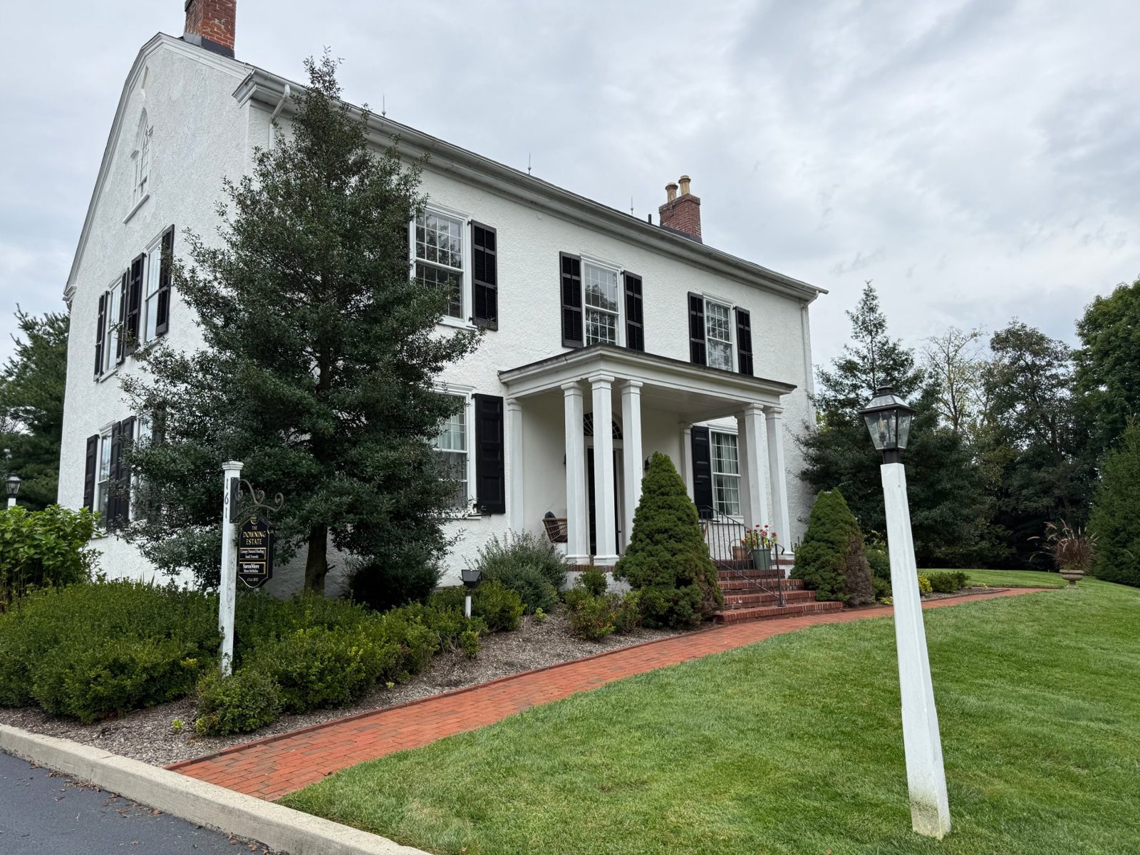 The white colonial building at 161 Byers Road in Chester Springs, with a brick walkway and columned porch